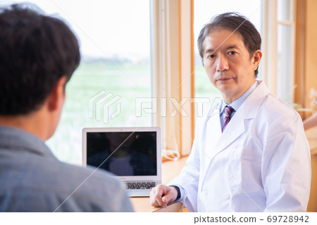 Doctor examining a man 69728942