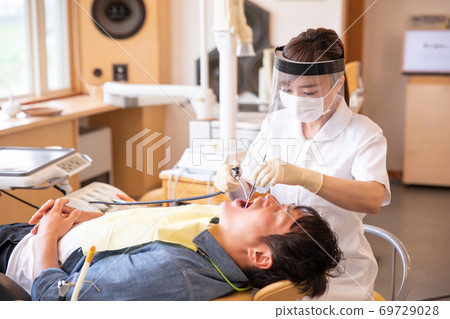 Dental hygienist and male patient 69729028