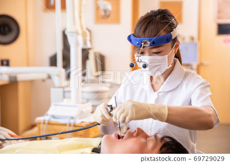 Asian dental hygienist and male patient 69729029