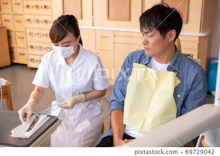 Dental hygienist and male patient Dental hygienist and male patient 69729042