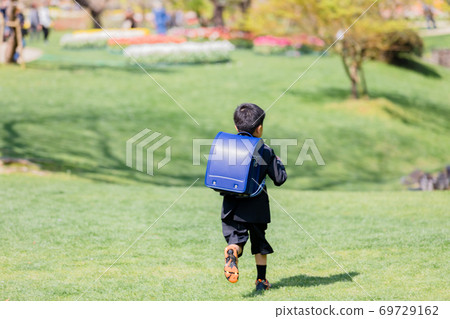 A boy carrying a school bag A boy carrying a school bag 69729162