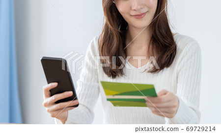 一個女人檢查她的智能手機上的存摺餘額 69729214