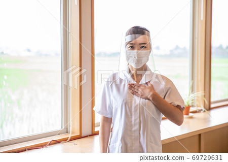Nurse doing face shield 69729631