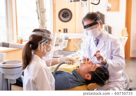 Doctors and dental hygienists treating patients Doctors and dental hygienists treating patients 69730735