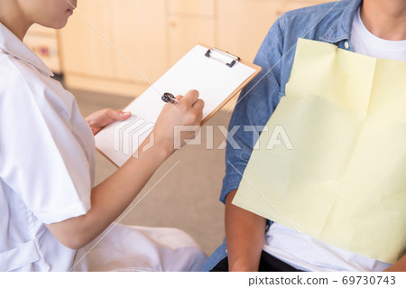 Male patient and dental hygienist 69730743