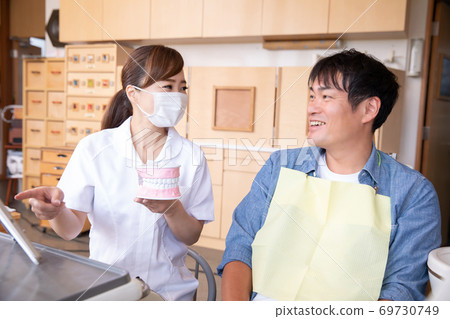 Dental hygienist and male patient 69730749