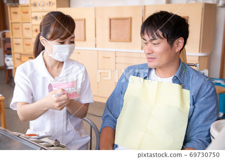 Dental hygienist and male patient Dental hygienist and male patient 69730750