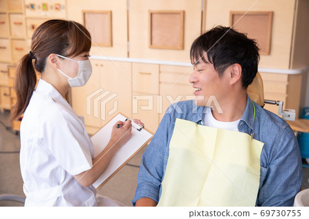 Dental hygienist and male patient Dental hygienist and male patient 69730755