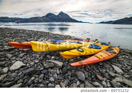 Double kayaks parked on the pier on scenic mountain ocean bay in Valdez, Alaska Double kayaks parked on the pier on scenic mountain ocean bay in Valdez, Alaska 69731232