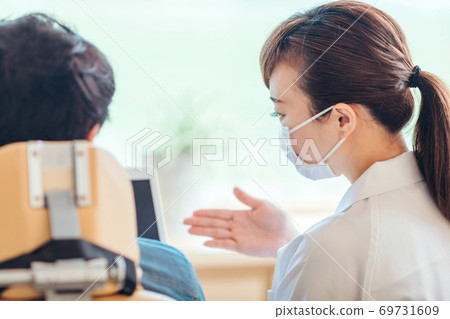 Dental hygienist and male patient 69731609