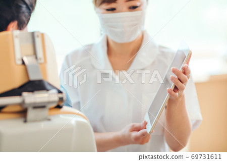 Dental hygienist and male patient 69731611