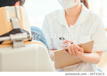 Dental hygienist and male patient Dental hygienist and male patient 69731613