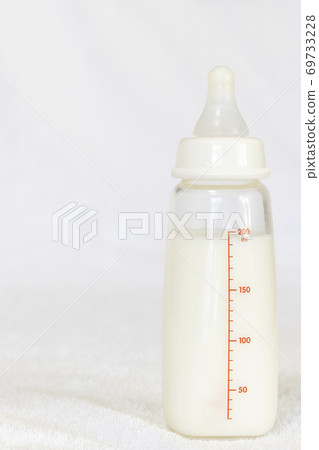 嬰兒奶瓶牛奶在白毛巾上 嬰兒奶瓶牛奶在白毛巾上 69733228