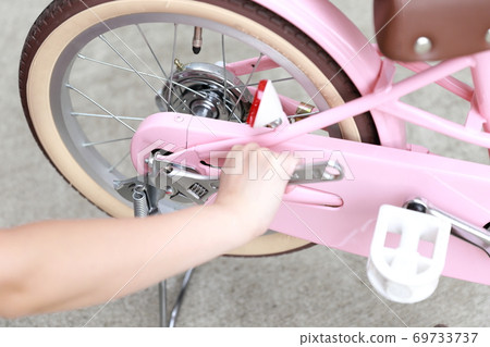 Woman removing training wheels and stand on bicycle Woman removing training wheels and stand on bicycle 69733737