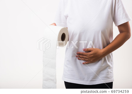 Woman diarrhea constipation holding tissue toilet paper roll on hand she crotch lower abdomen Woman diarrhea constipation holding tissue toilet paper roll on hand she crotch lower abdomen 69734259
