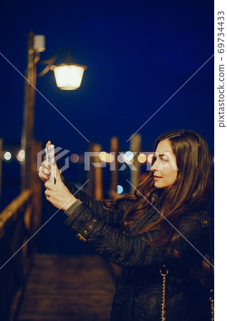 girl talking on the phone and taking pictures in Venice 69734433