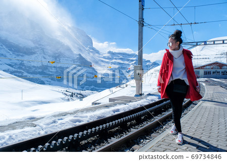 Asian woman in train station, Switzerland 69734846