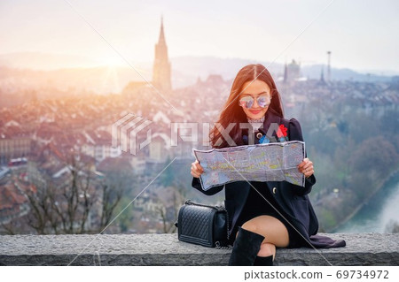 female tourist with map looking for a way to Beautiful view point old town in Bern, Switzerland. 69734972