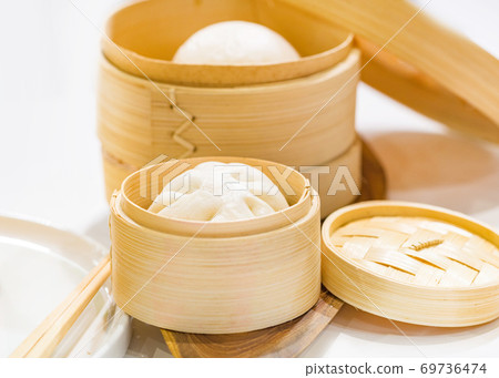 Chinese dumpling steamed buns, Steamed bun served in wooden basket 69736474