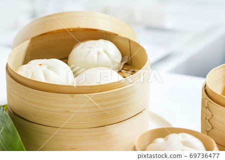 Chinese dumpling steamed buns, Steamed bun served in wooden basket Chinese dumpling steamed buns, Steamed bun served in wooden basket 69736477