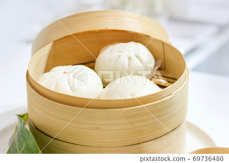 Chinese dumpling steamed buns, Steamed bun served in wooden basket 69736480