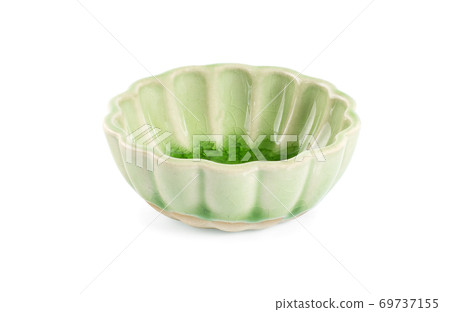 Green handmade pottery cup on white background 69737155