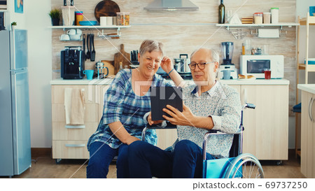 Senior couple on video call with grandchildrens 69737250