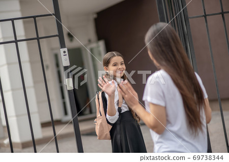 Dark-haired mom sending her daughter to school Dark-haired mom sending her daughter to school 69738344