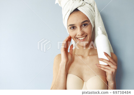Beautiful girl standing in a studio with cream Beautiful girl standing in a studio with cream 69738484