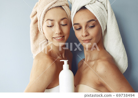 Beautiful girls standing in a studio with cream Beautiful girls standing in a studio with cream 69738494