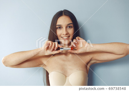 Beautiful girl standing in a studio with red lipstick 69738548