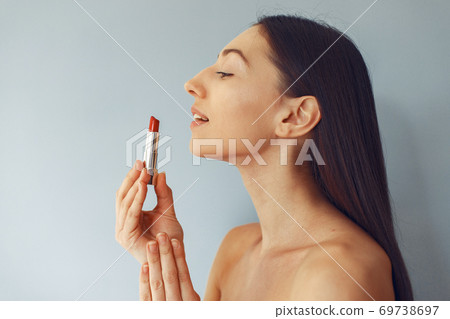 Beautiful girl standing in a studio with red lipstick 69738697
