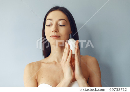 Beautiful girl standing in a studio with cream Beautiful girl standing in a studio with cream 69738712