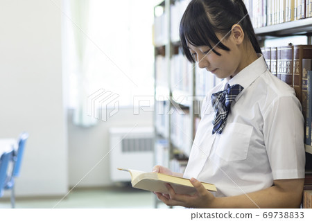 A girl choosing a book A girl choosing a book 69738833