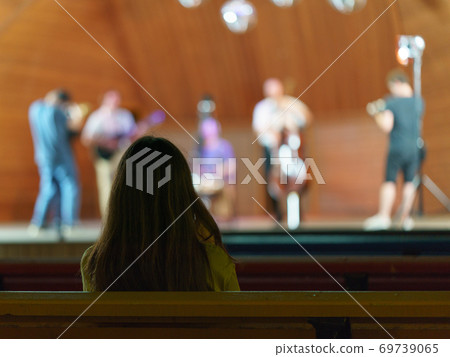 Young woman hearing music show in the public park in night time. Back / rear view. Silhouette of head. Long hair. Concept of holidays, leisure and weekend. Coronavirus pandemic - nobody else. Young woman hearing music show in the public park in night time. Back / rear view. Silhouette of head. Long hair. Concept of holidays, leisure and weekend. Coronavirus pandemic - nobody else. 69739065