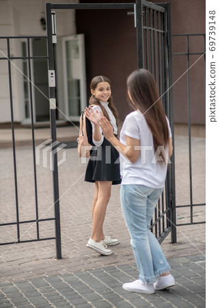 Long-haired mom sending her daughter to school Long-haired mom sending her daughter to school 69739148