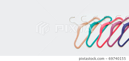 Sustainable responsible consumption concept. Many bright multi-colored velvet pop color hangers on white background. Store, sale, design, empty hanger 69740155