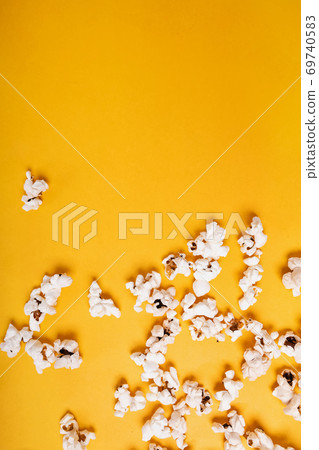 Popcorn scattered on yellow background 69740583