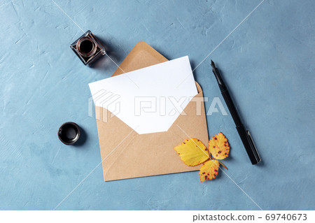 Autumn stationery mockup, a blank A5 greeting card or invitation in a brown kraft envelope, overhead flat lay shot with ink 69740673