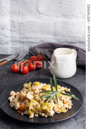 Stewed chicken minced meat with vegetables zucchini pepper spices on a black plate. copy space. Stewed chicken minced meat with vegetables zucchini pepper spices on a black plate. copy space. 69740982