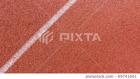 White painted line on tartan ground track in a athleticism and sports field. White painted line on tartan ground track in a athleticism and sports field. 69741601