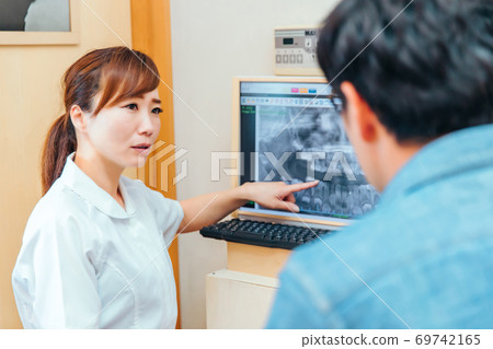 Dental hygienist and male patient Dental hygienist and male patient 69742165