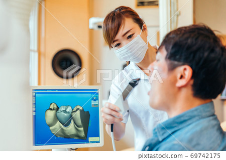 Dental hygienist and male patient Dental hygienist and male patient 69742175