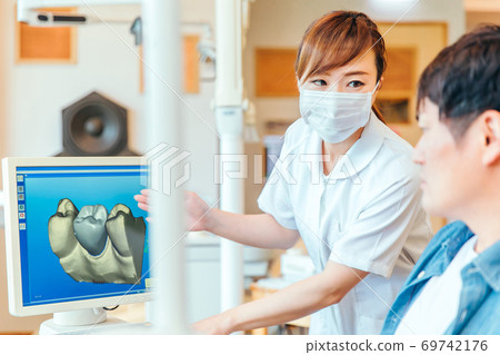 Dental hygienist and male patient 69742176