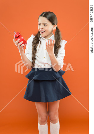 Avoid being late. Schoolgirl hold alarm clock. Time to studyell schedule. Schooltime concept 69742622