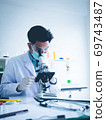 Asian male scientist Is working seriously Chemistry experiment With looking at the microscope In the laboratory, the color tone image. 69743487