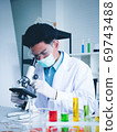 Asian male scientist Is working seriously Chemistry experiment With looking at the microscope In the laboratory, the color tone image. 69743488