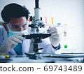 Asian male scientist Is working seriously Chemistry experiment With a microscope In the laboratory, the color tone image. 69743489