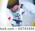 Asian male scientist Is working seriously Chemistry experiment With a microscope In the laboratory, the color tone image. 69743494