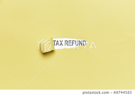 Yellow broken paper background with the word TAX REFUND. Finance 69744583